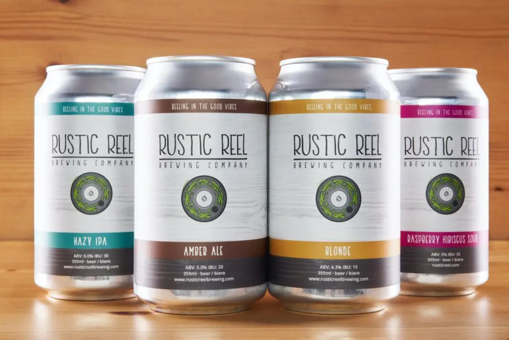Four craft beer cans, Hazy IPA, Amber Ale, Blonde and Sour, on a wooden background