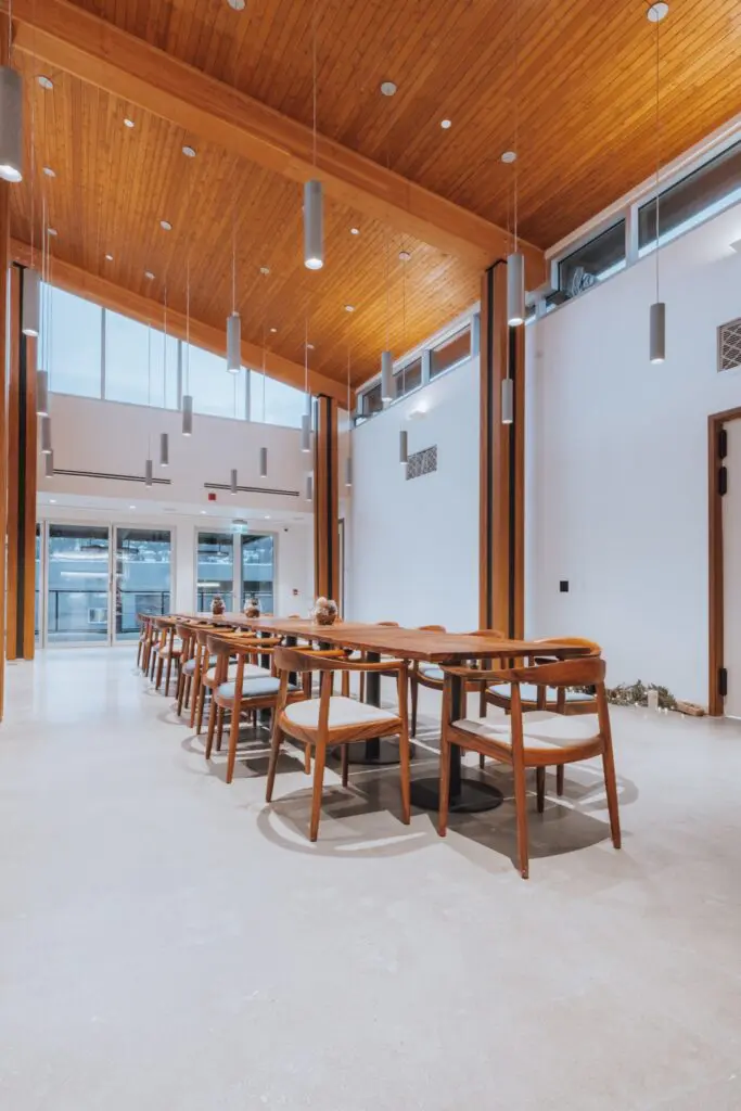 Long wooden dining table and chairs under a high wood ceiling in the tasting and dining room at Mt. Boucherie Estate Winery